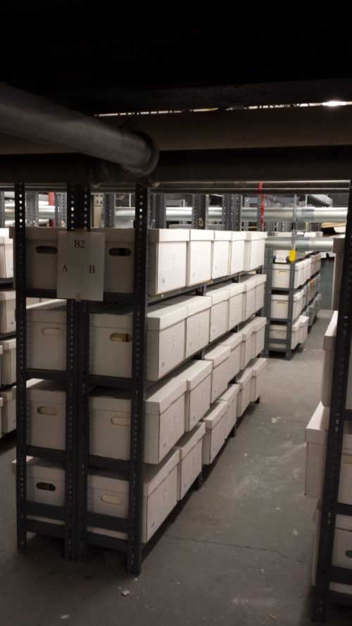 white Hollinger boxes line the rows of shelving