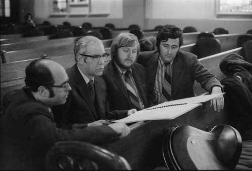 During a rehearsal in Lake Avenue Baptist Church, Eastman School composers Samuel Adler, Wayne Barlow, and Joseph Schwantner peruse the score of the Concerto for Organ and Orchestra, joined (at right) by local music critic Ted Price.