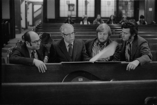 During a rehearsal in Lake Avenue Baptist Church, Eastman School composers Samuel Adler, Wayne Barlow, and Joseph Schwantner peruse the score of the Concerto for Organ and Orchestra, joined (at right) by local music critic Ted Price.