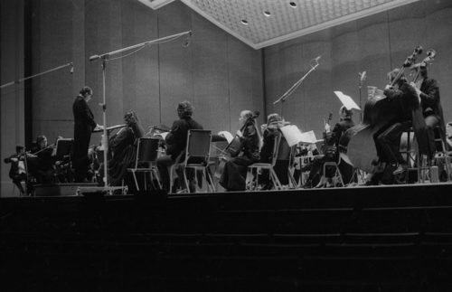 Eastman Philharmonia concert that featured the premiere of Krzystof Penderecki’s Partita for Harpsichord and Orchestra. At the conclusion of the Partita, Maestro Hendl invites the composer to the stage for bows. In the last shot, the composer, the soloist, and the conductor all join hands to acknowledge the applause.