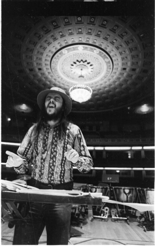 Chuck Mangione on the podium in the Eastman Theater, captured by Louis Ouzer during a rehearsal. This striking sequence is emblematic of Mr. Ouzer’s penchant of capturing conductors on the podium with the visually imposing chandelier in the background.