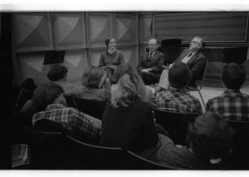 Mr. Schonberg speaking from the stage in Howard Hanson Hall. Professor Donald Shetler of the Music Education Department sits to his left.