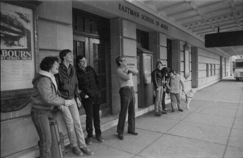 Onlookers outside the Eastman School of Music react as they watch the demolition work in progress on the opposite side of Gibbs Street.