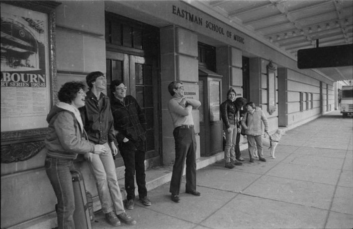 Onlookers outside the Eastman School of Music react as they watch the demolition work in progress on the opposite side of Gibbs Street.