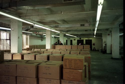 team members Brodsky, Coppen and Quinn are seen among the lines of shipping crates