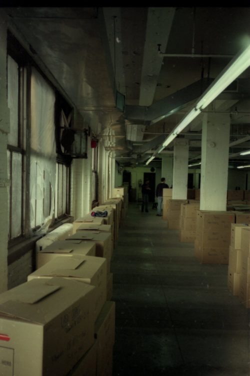 team members Brodsky, Coppen and Quinn are seen among the lines of shipping crates