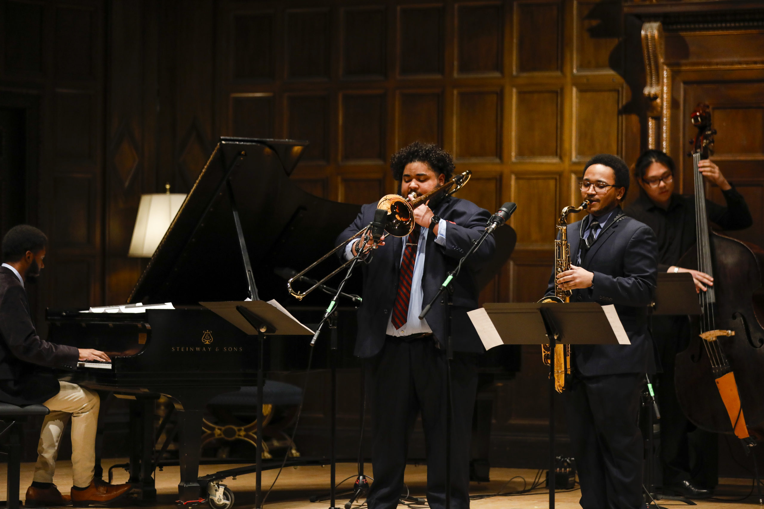 Students on stage in Kilbourn Hall playing piano, trombone, saxophone and bass for Eastman's Black History Month showcase performance